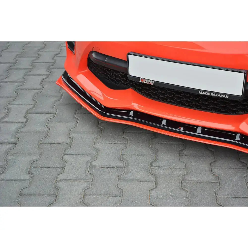 Front splitter på Toyota GT86 Facelift V.4, nærbilde av sort plast montert under oransje støtfanger.