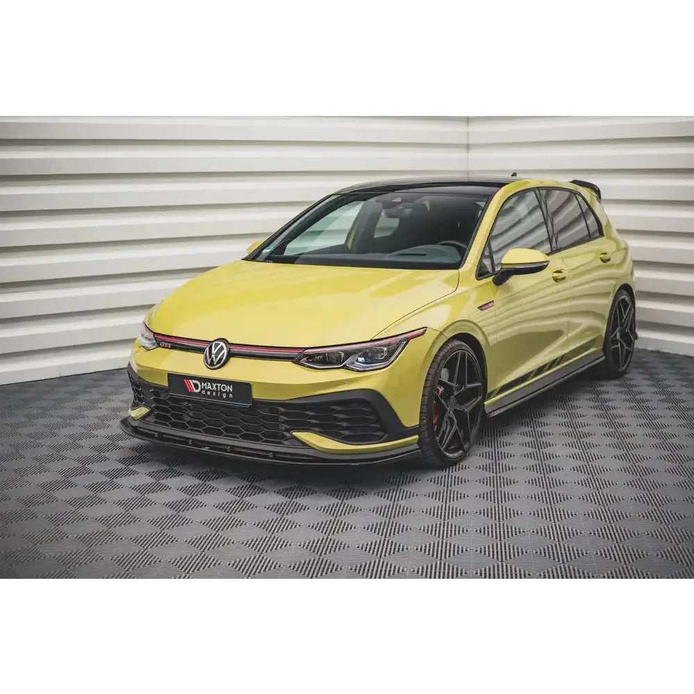 Frontspoiler på Volkswagen Golf 8 GTI Clubsport, gul bil med sorte felger og røde detaljer i grillen.