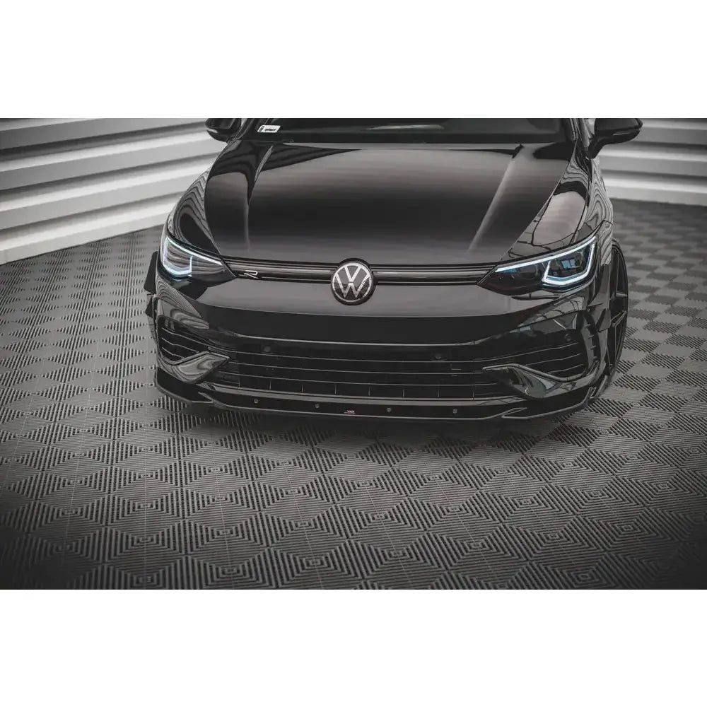 Spoiler til Volkswagen Golf R Mk8 V.4 i sort blank finish, fokus på grill og frontlykter, sett skrått forfra.