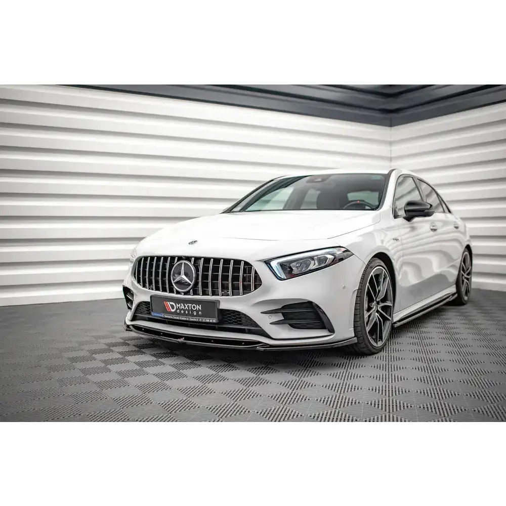 Front splitter på hvit Mercedes A35 AMG W177 med sorte detaljer og sportsfelger, sett forfra fra venstre.