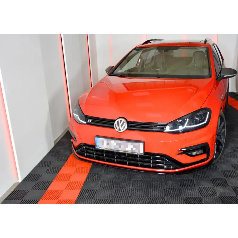 Frontleppe VW Golf 7 R Facelift V.7 montert på rød bil med svarte detaljer, sett skrått forfra innendørs.