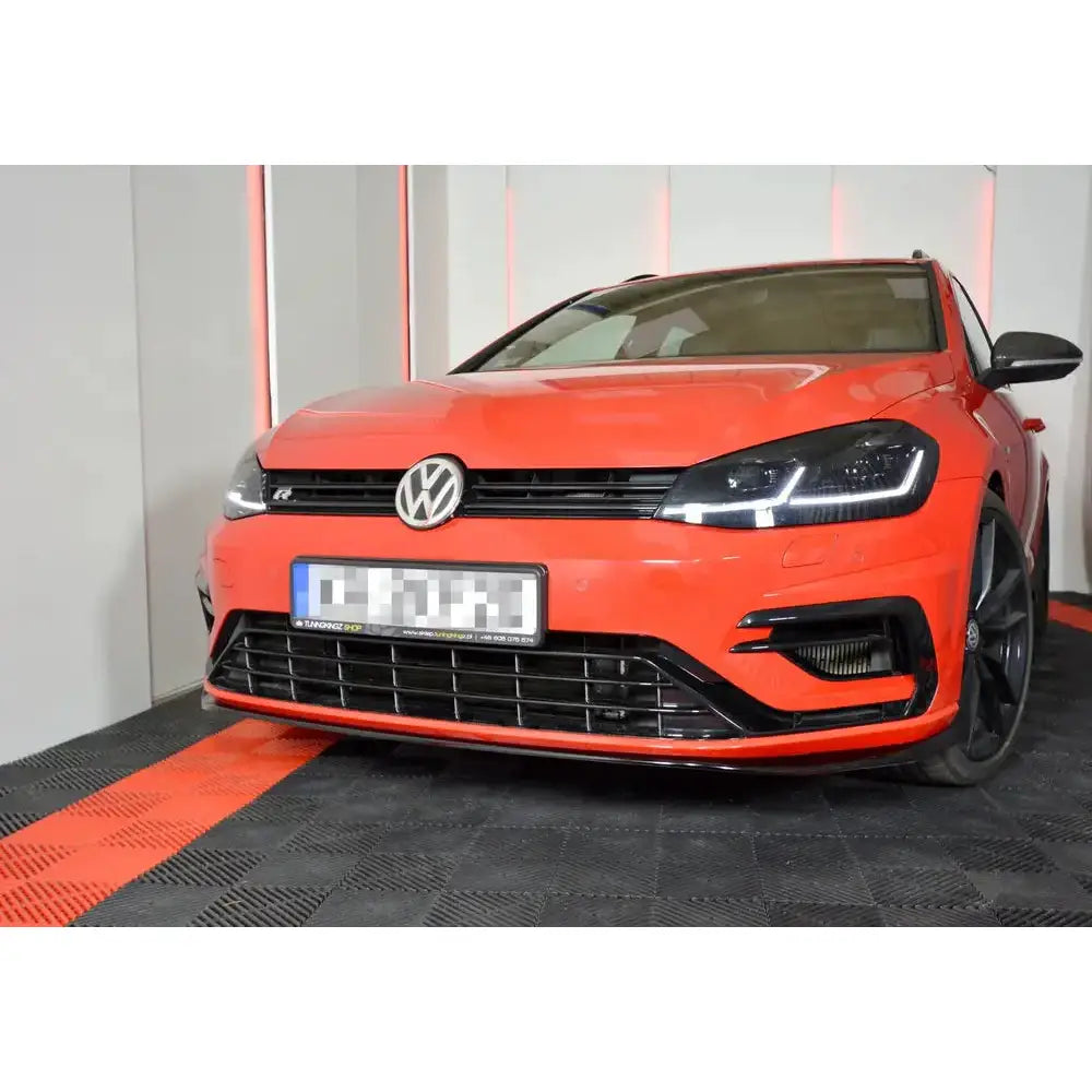 Spoiler på VW Golf 7 R Facelift V.7, rød bil forfra fra venstre med LED-lykter og svart grill.