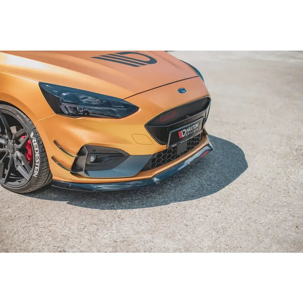 Spoiler på Ford Focus ST MK4, nærbilde av oransje front med sorte detaljer og synlige sportsfelger.