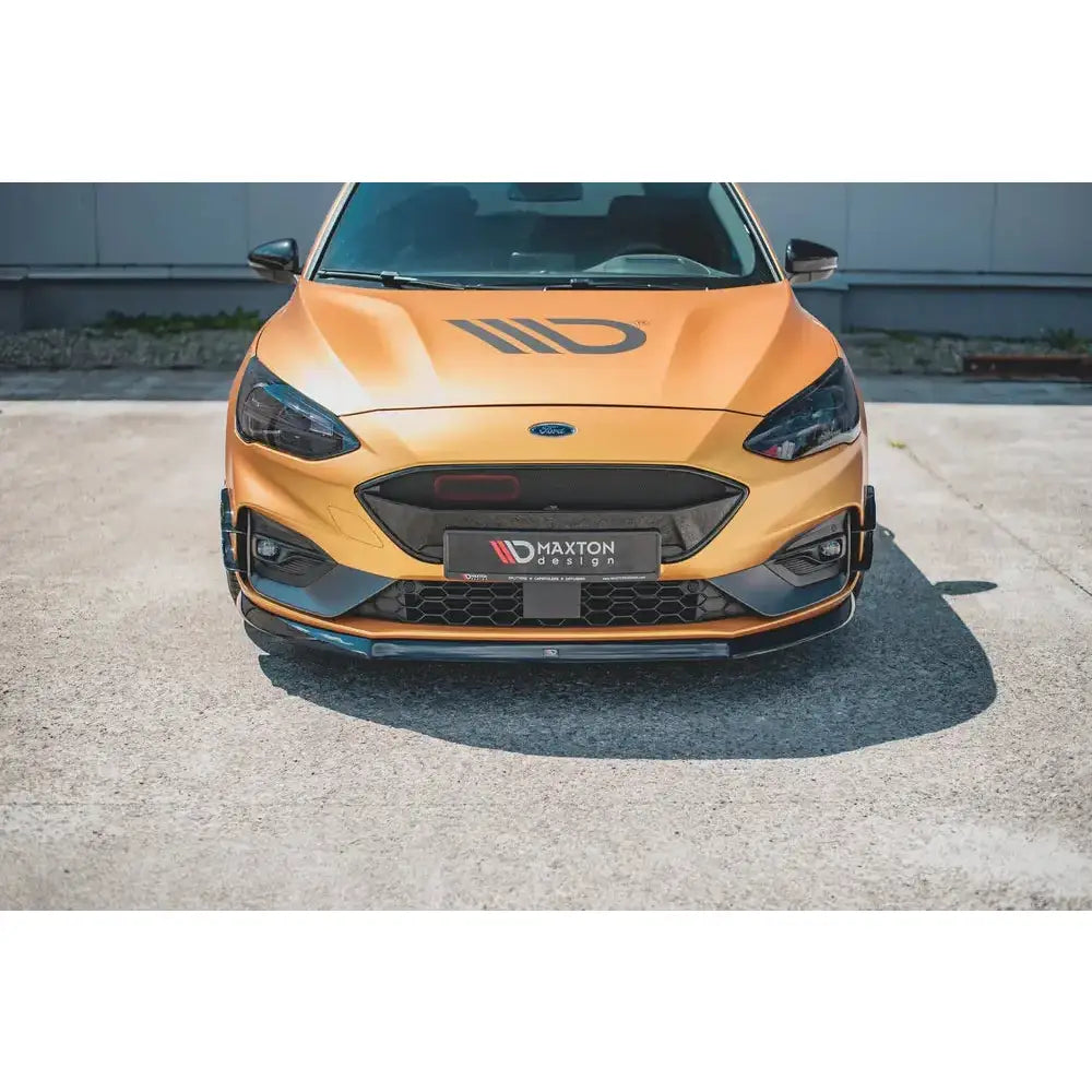 Front splitter på oransje Ford Focus ST med svart grill, Maxton Design-logo og dekorstriper på panseret.