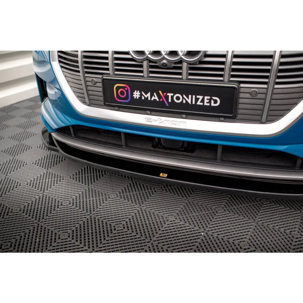 Front splitter på Audi e-tron V1, sort spoiler under blå bilfront med sølvgrill og skilt med #MAXTONIZED.