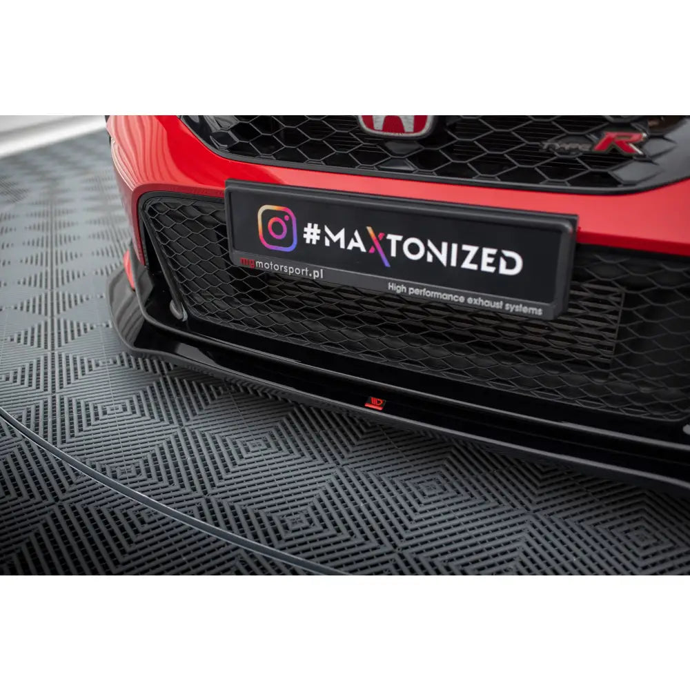 Front splitter på Honda Civic Type-R Mk 11 V1 med sort grill og rød logo, fotografert fra lav vinkel.