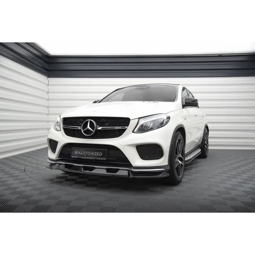 Frontleppe på hvit Mercedes GLE Coupe 43 AMG med svarte detaljer og markant spoiler, sett skrått forfra.