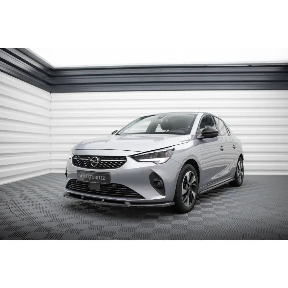 Frontleppe på Opel Corsa F V1 sølvfarget bil sett fra venstre forhjørne i lyst utstillingsrom.