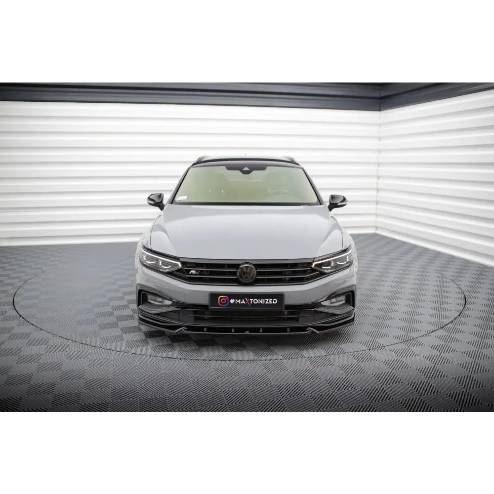 Frontspoiler på Volkswagen Passat R-Line B8 Facelift sett forfra med sorte detaljer i lyst studio.