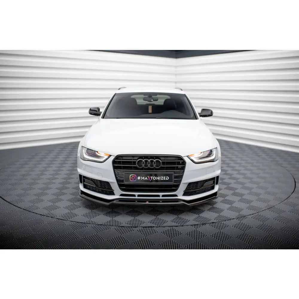 Frontspoiler på Audi A4 Competition B8 Facelift hvit bil sett forfra i lyst studio med rutet gulv.