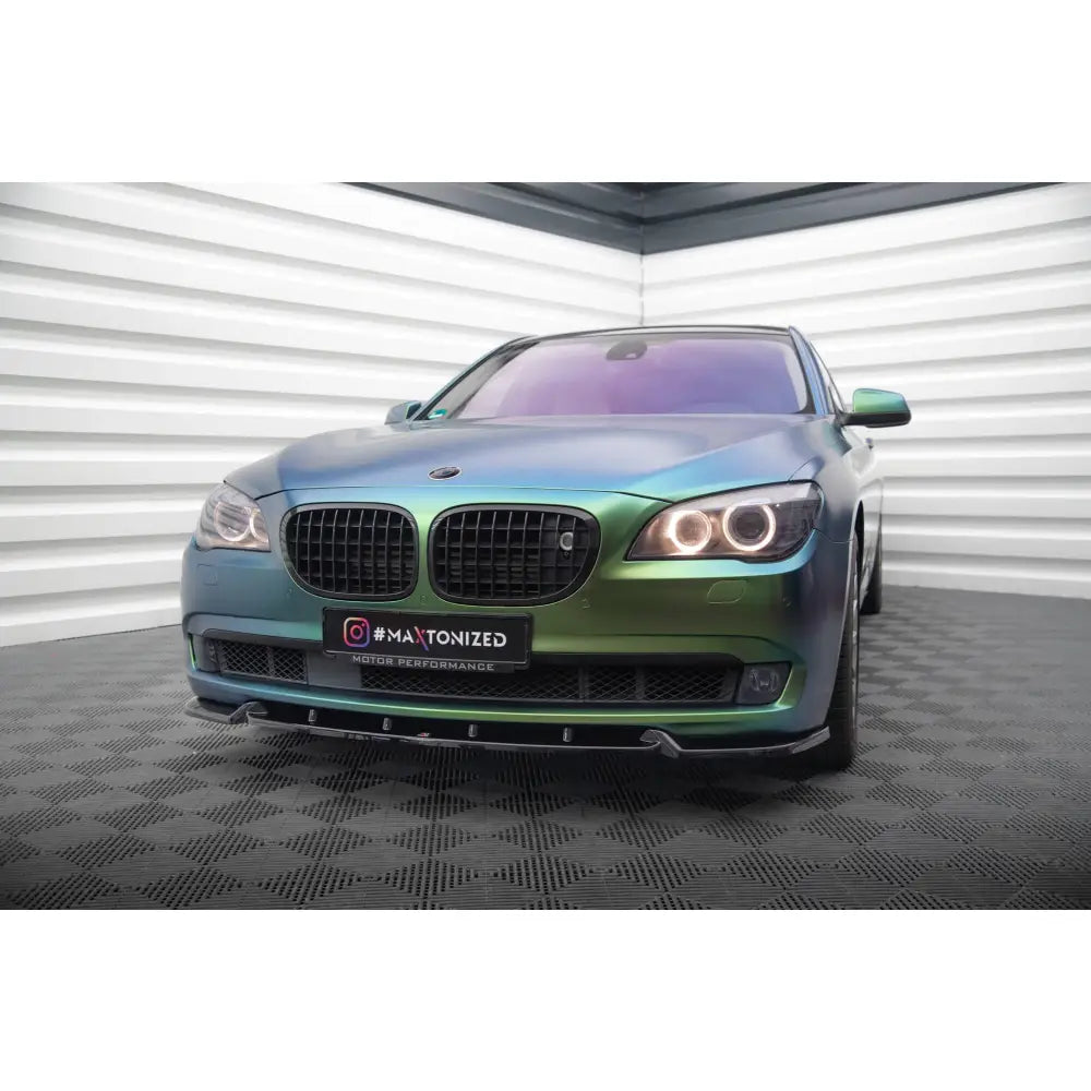 Frontleppe på BMW 7 F01 V2 med grønn-blå folie og svarte grilldetaljer, sett forfra i halvprofil.