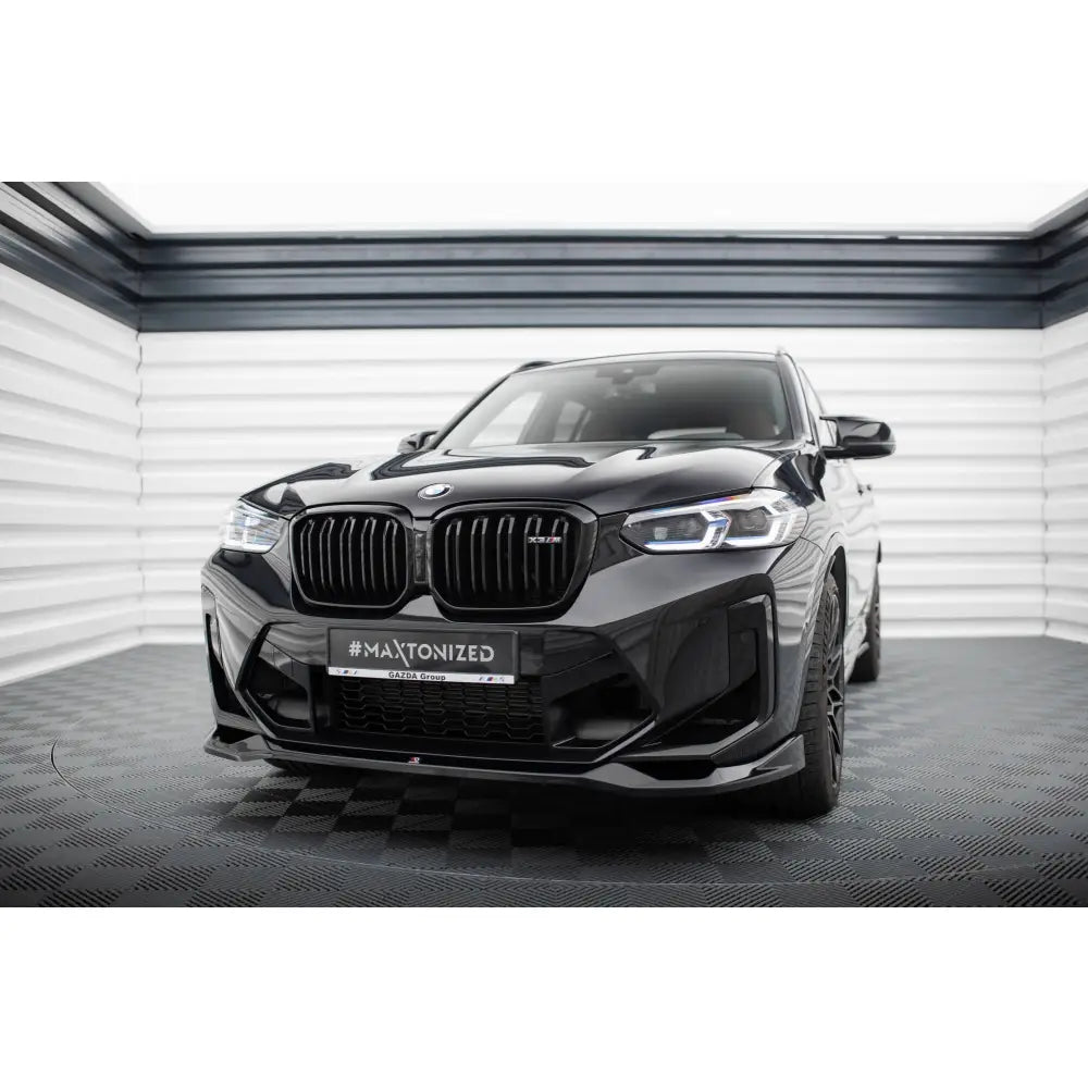 Frontspoiler BMW X3 M F97 Facelift V2 sett forfra med sorte felger og LED-frontlykter i lyst rom.