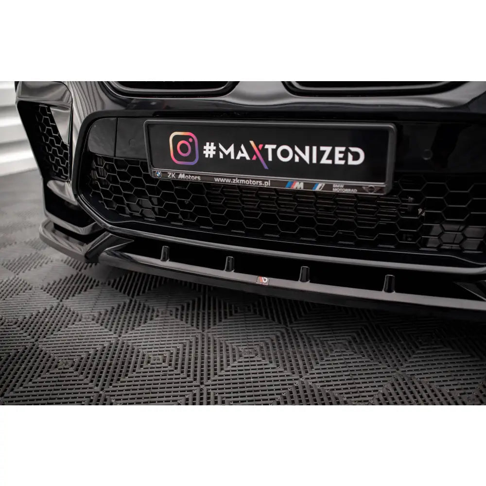 Front splitter på BMW X6 M F96 V2, sort spoiler foran med bikubemønstret grill og synlig logo.