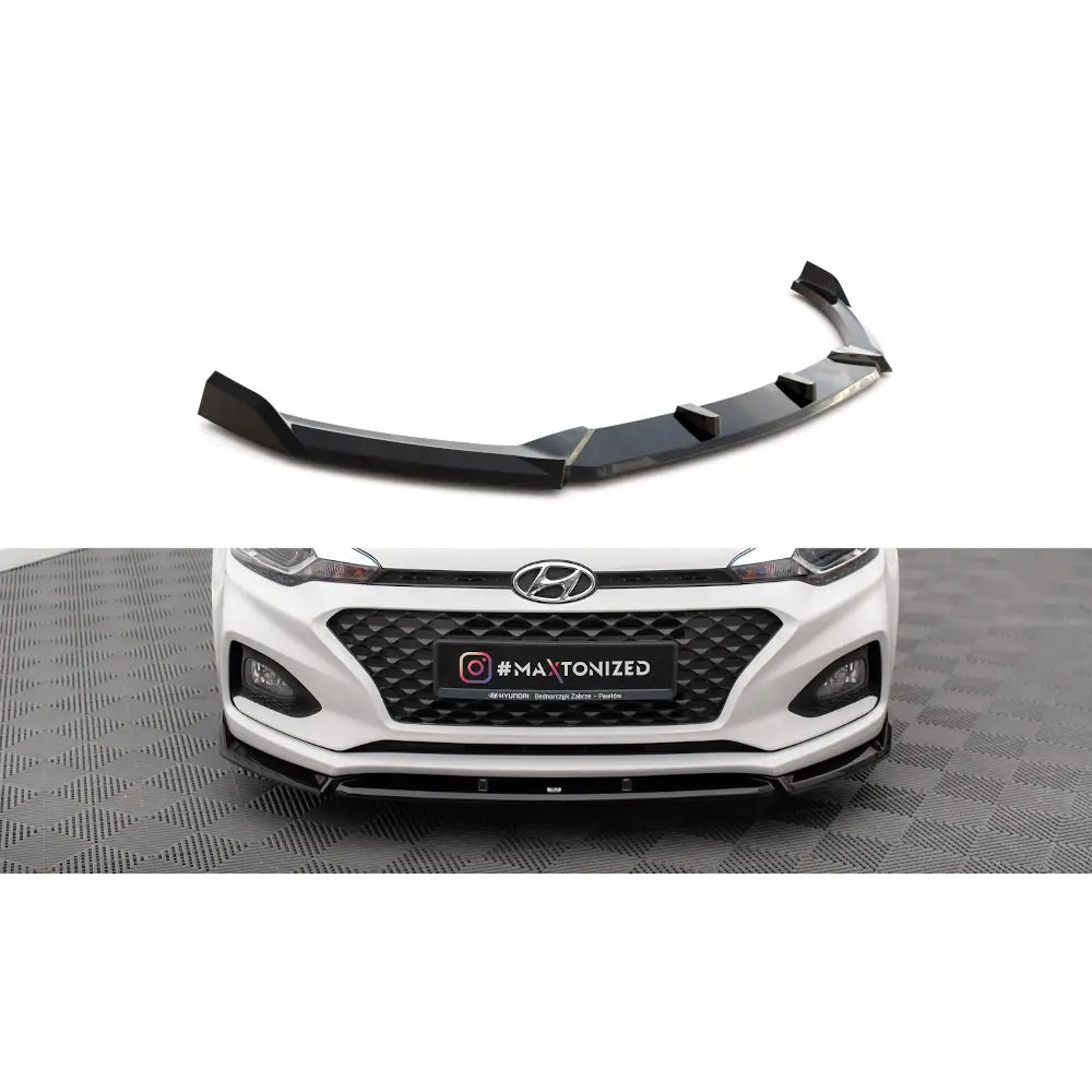 Frontspoiler Hyundai I20 Mk2 Facelift V2 i sort plast, montert på hvit bil med sporty, markerte linjer.