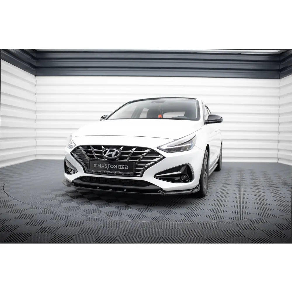 Frontleppe på Hyundai I30 Mk3 Facelift V2 sett rett forfra i lyst rom med sort grill og detaljer.