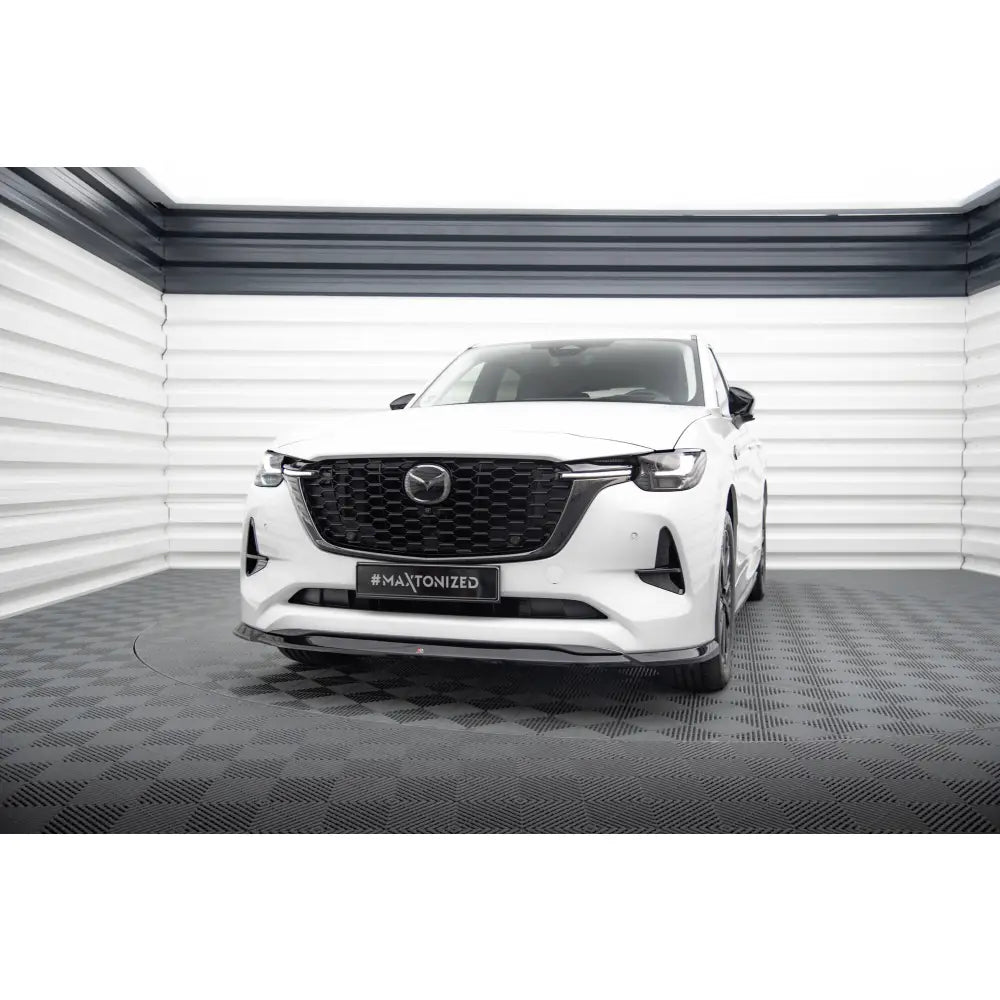 Frontleppe på Mazda CX-60 Mk1 V2, hvit bil med sort grill og sportslig spoiler, sett rett forfra.