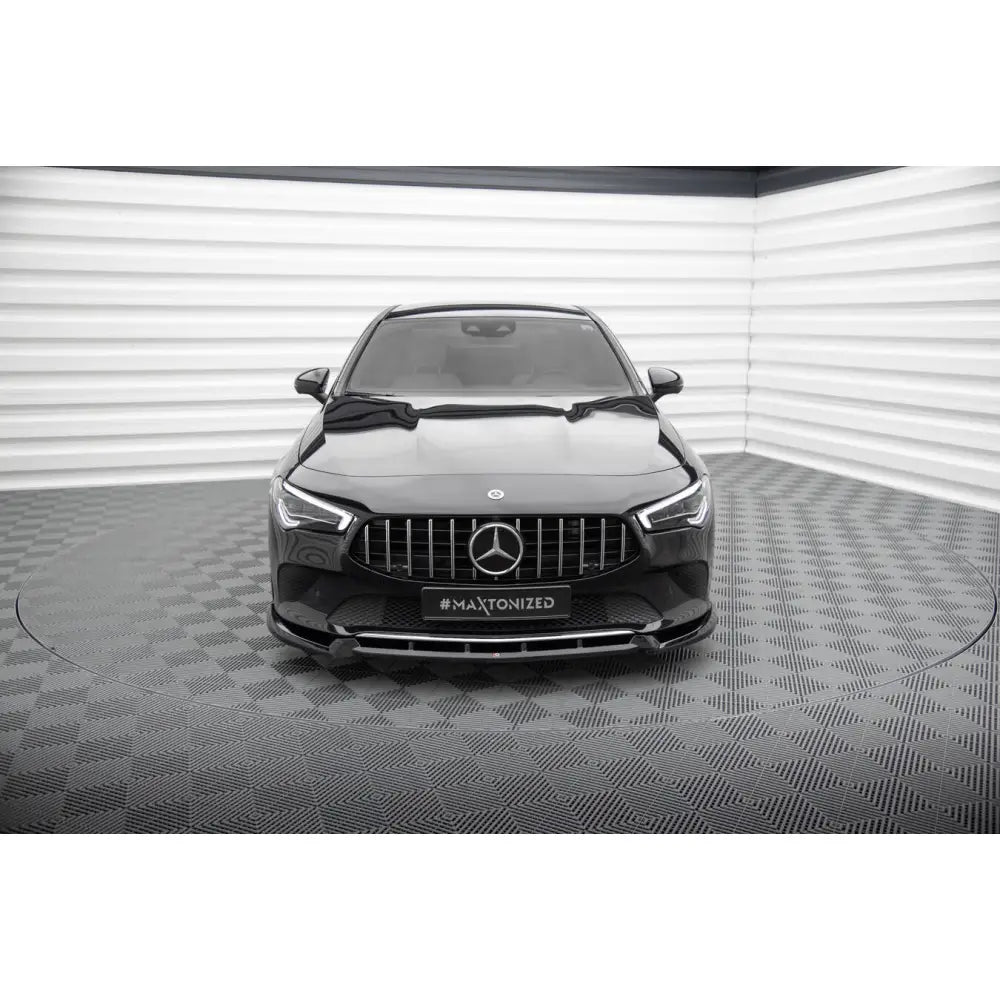 Frontleppe på Mercedes CLA C118 V2, svart bil sett forfra med krom grill og markant spoiler.