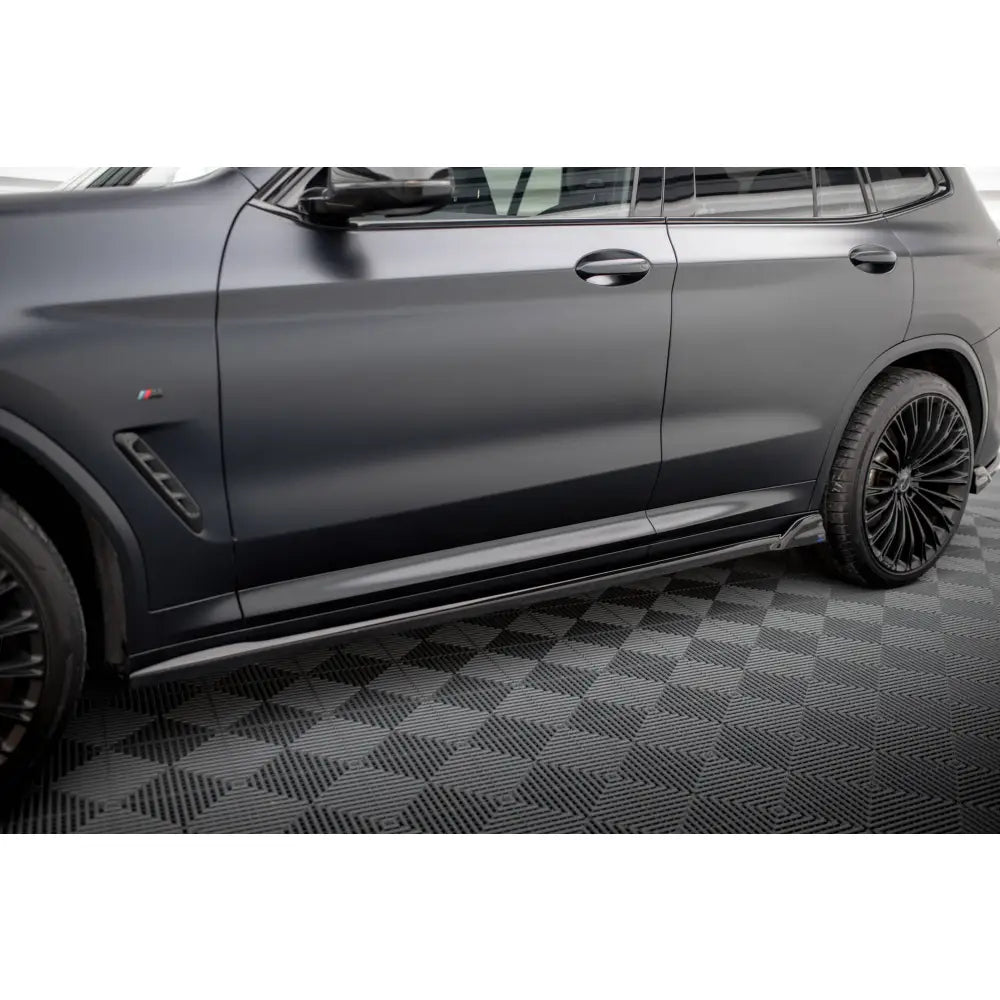 Front splitter på sort Porsche 718 Cayman 982c med aluminiums sidekjørerist og sorte felger.