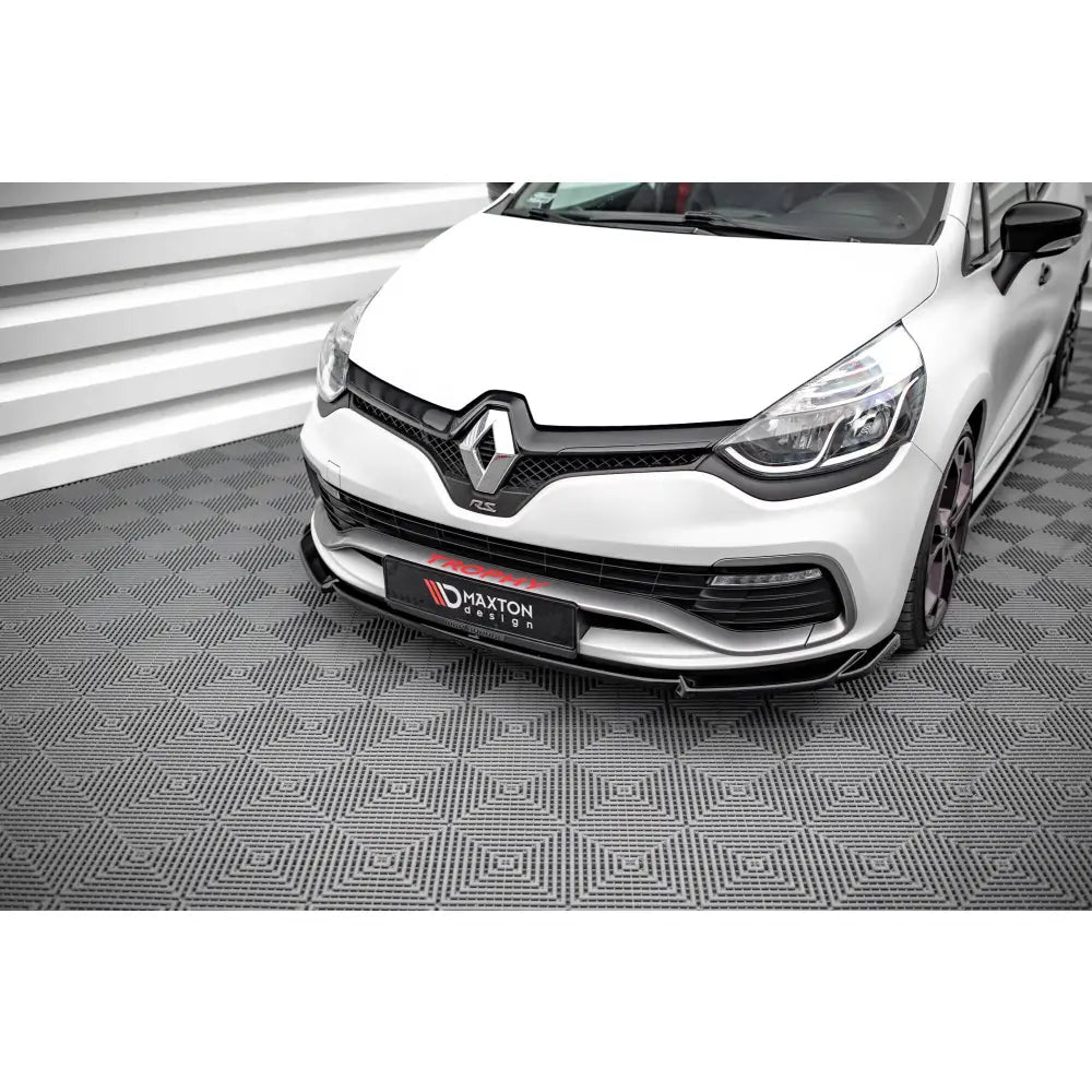 Front splitter på hvit Renault Clio RS Mk4 V2 sett forfra med svarte detaljer og markerte frontlykter.