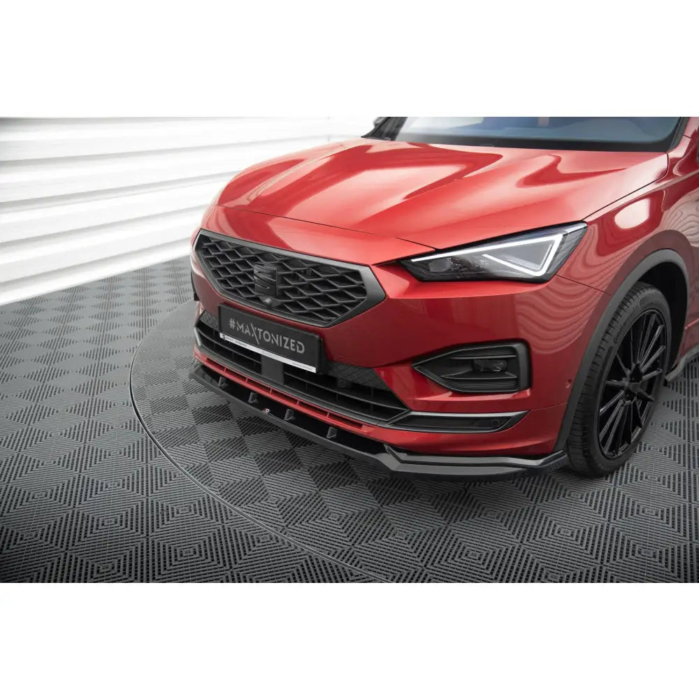 Spoiler til Seat Tarraco FR Mk1 V2 montert på rød bil med sort grill og LED-lys, sett fra skrå vinkel.