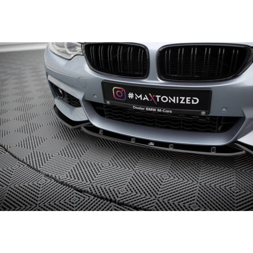 Front splitter på BMW 4 F32 Coupe M-Pack V3 i blank sort plast, nærbilde mot mønstrete gulvfliser.