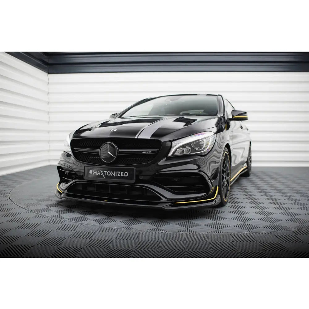Front splitter på Mercedes CLA 45 V4 Aero C117 Facelift med gule detaljer, sett skrått forfra i lyst rom.