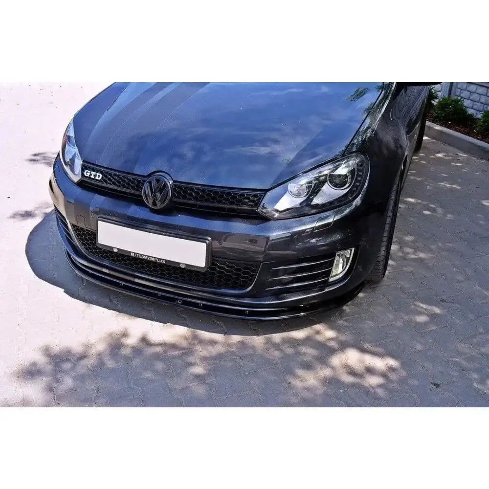 Frontleppe på VW Golf VI GTI V.2, sort bil i halvprofil med fokus på spoiler, grill og lykter.