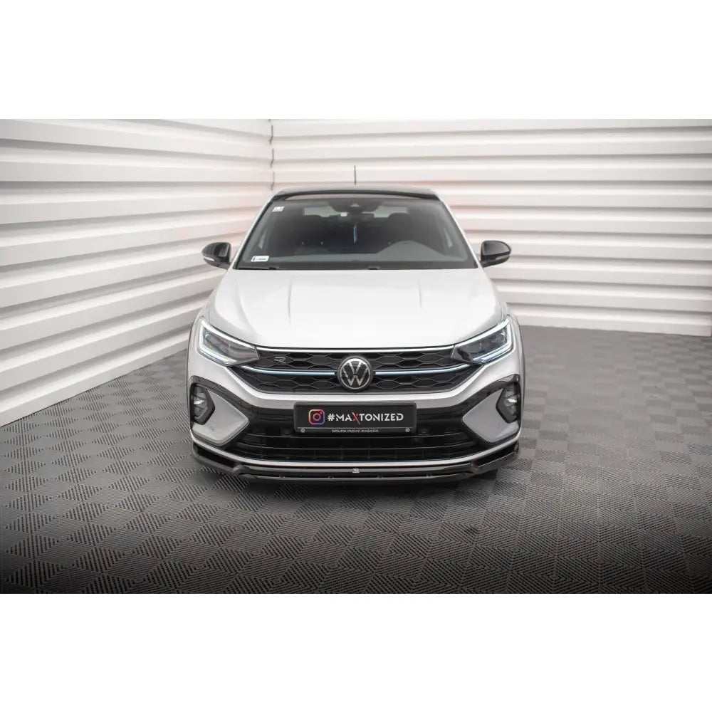 Frontleppe på Volkswagen Taigo R-Line Mk1, hvit bil forfra med sorte detaljer og synlig VW-logo.