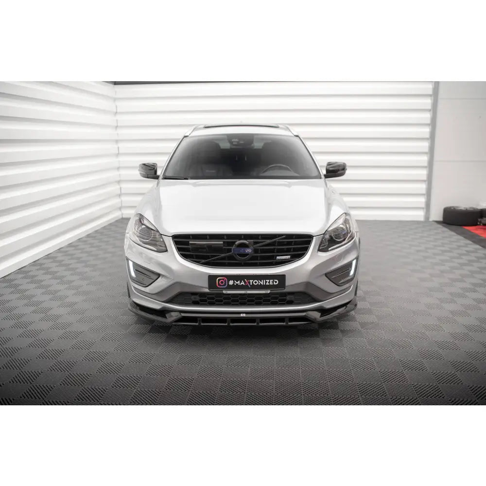 Frontleppe på Volvo XC60 R-Design Mk1 Facelift, sølvfarget SUV sett rett forfra med svart grill.