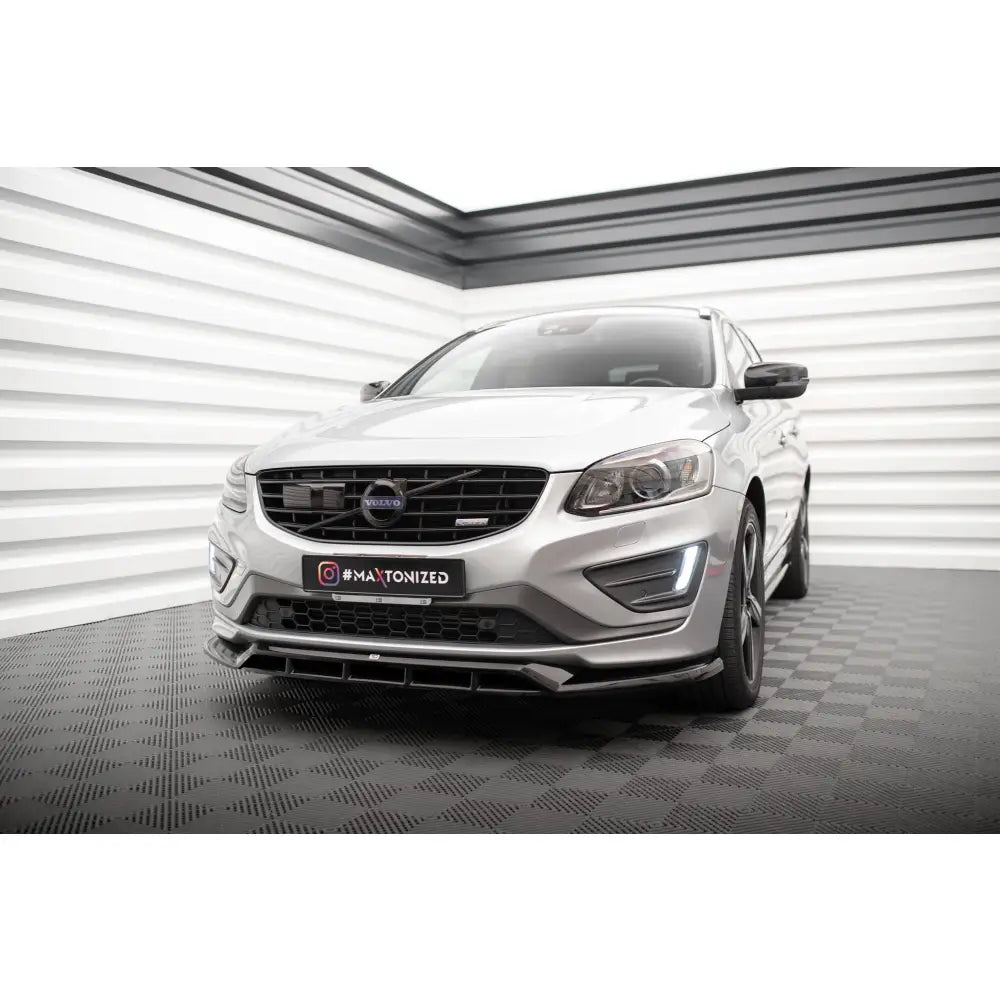 Spoiler til Volvo XC60 R-Design Mk1 Facelift sett forfra med sorte detaljer, innendørs miljø.