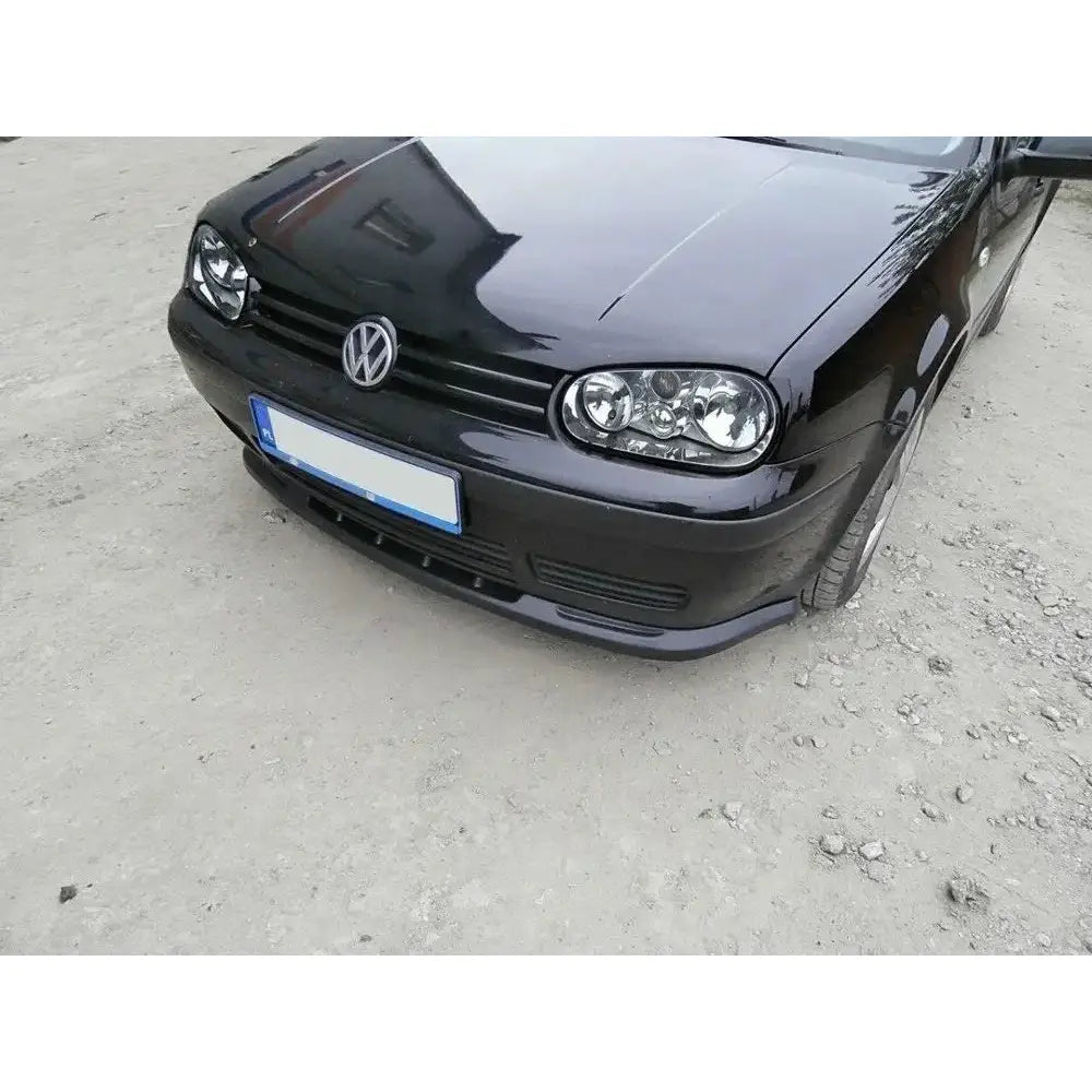Frontspoiler VW Golf IV sort bil med blank lakk, synlig grill og frontlykter sett skrått forfra.