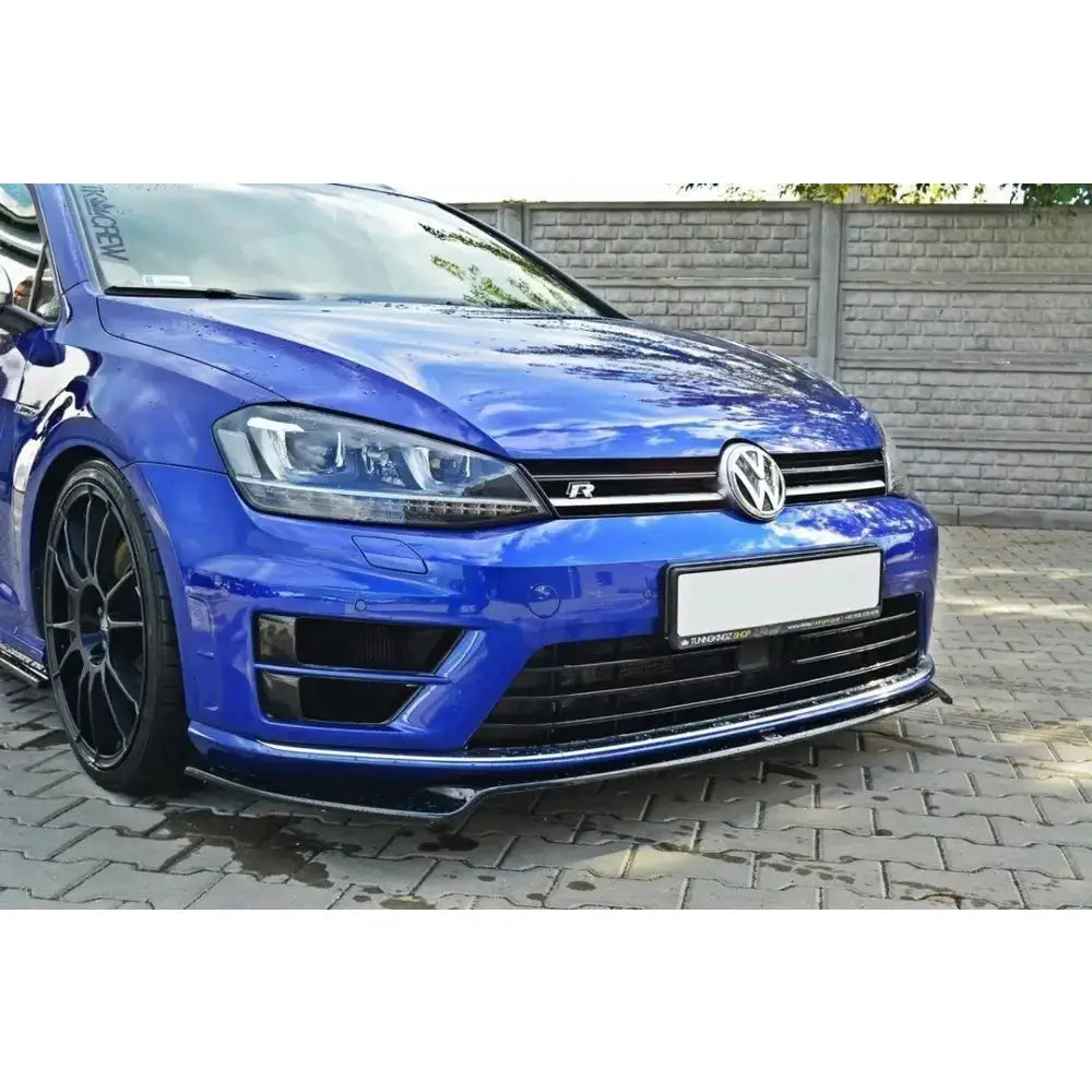 Frontleppe på VW Golf Mk7 R V.2, blå bil med svarte felger parkert foran murvegg.