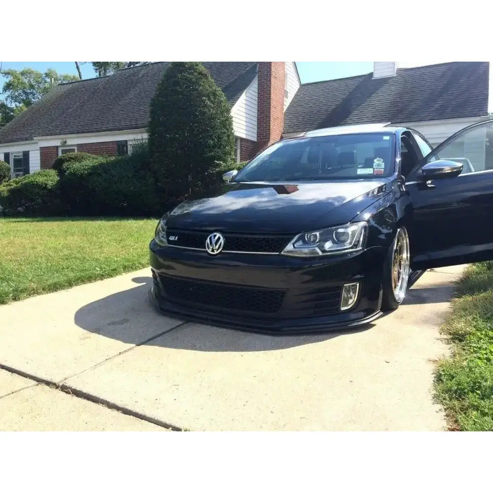 Frontleppe på VW Jetta VI GLI, sort bil med senket understell og åpen høyre fordør, sett forfra.