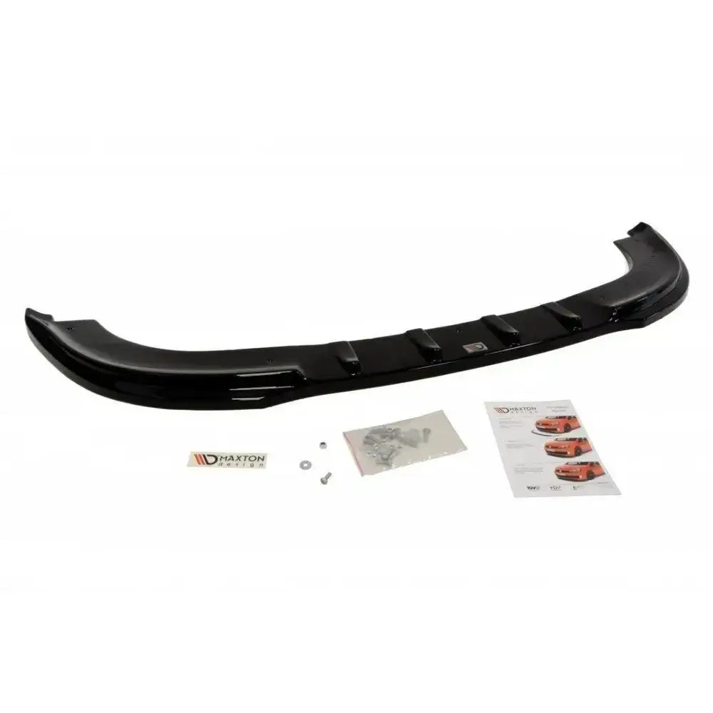 Spoiler til VW Touran i svart glanset plast sett ovenfra med monteringsutstyr, klistremerke og manual.