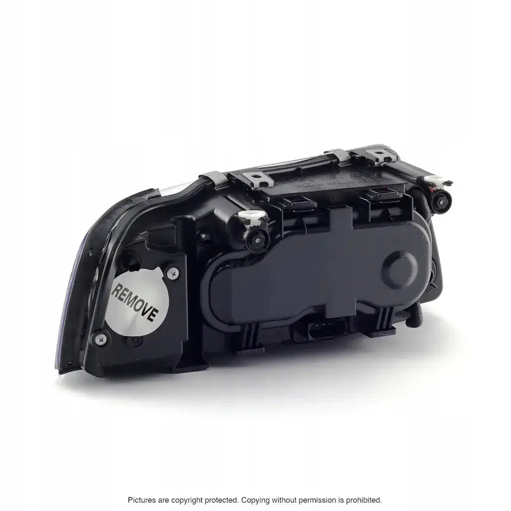 Hovedlys Audi A3 8L bakfra med svart plast, tekniske detaljer og hvit etikett merket REMOVE.