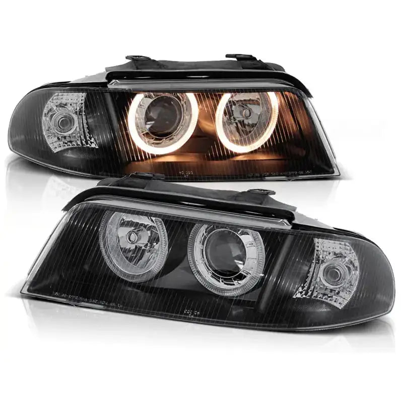 Frontlykter Audi A4 Angel Eyes Black med klare linseglass og lysende halo-ringer, sett forfra.