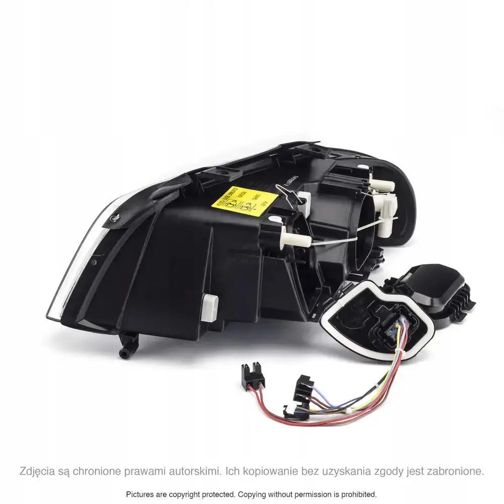 Headlamp Audi A4 B5 frontlykt sett fra skrå bakside med ledninger, koblinger og gul informasjonslapp.