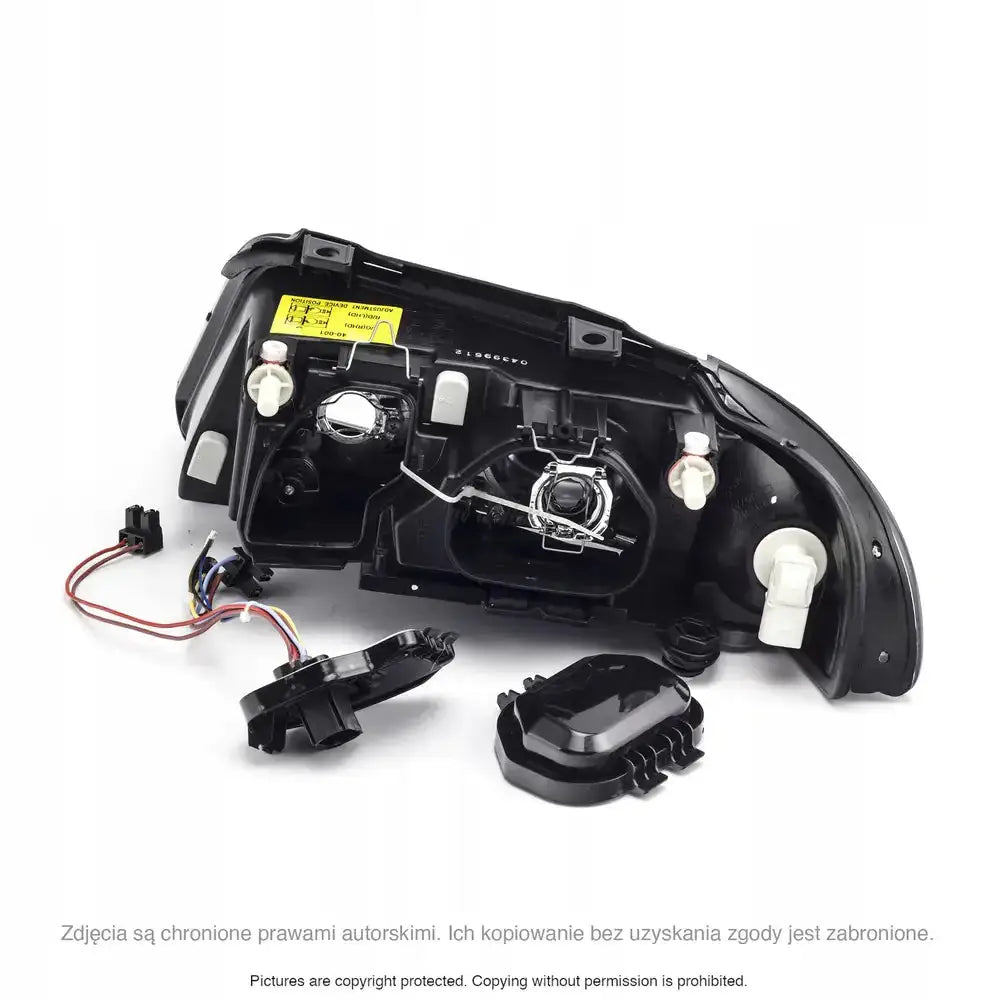 Hovedlys Audi A4 B5 bakside med sorte plastdeksler, reflektorer og synlig ledningsnett.