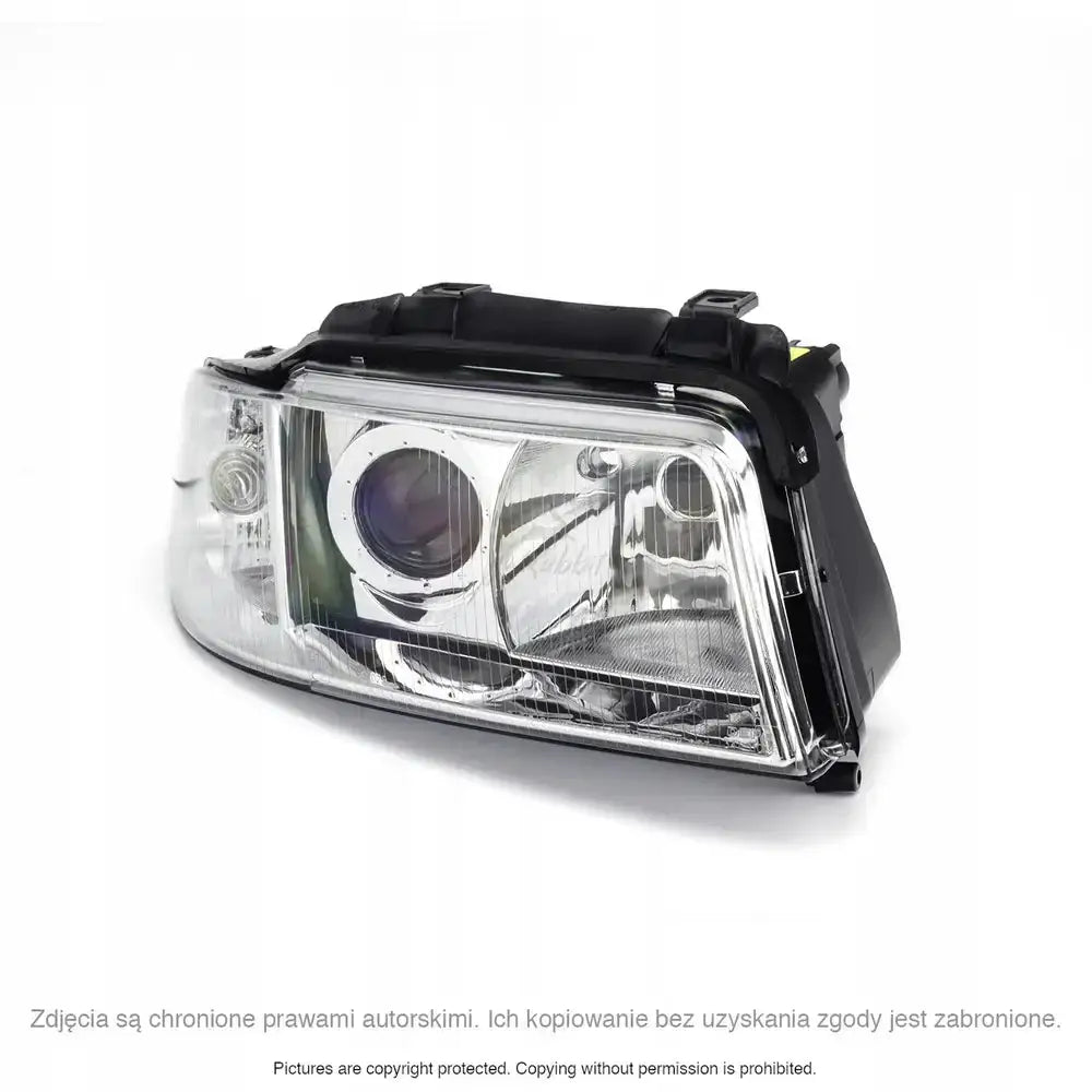 Hovedlys Audi A4 B5 frontlykt i klart glass med sorte detaljer, sett fra skrå forsidevinkel.