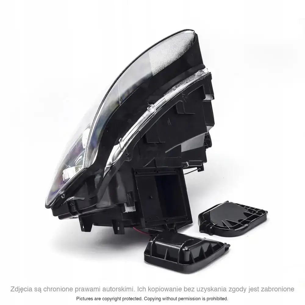 Hovedlykter Audi A4 B6 sort med klart glass, vist fra siden med avtagbare bakdeksler ved siden av.