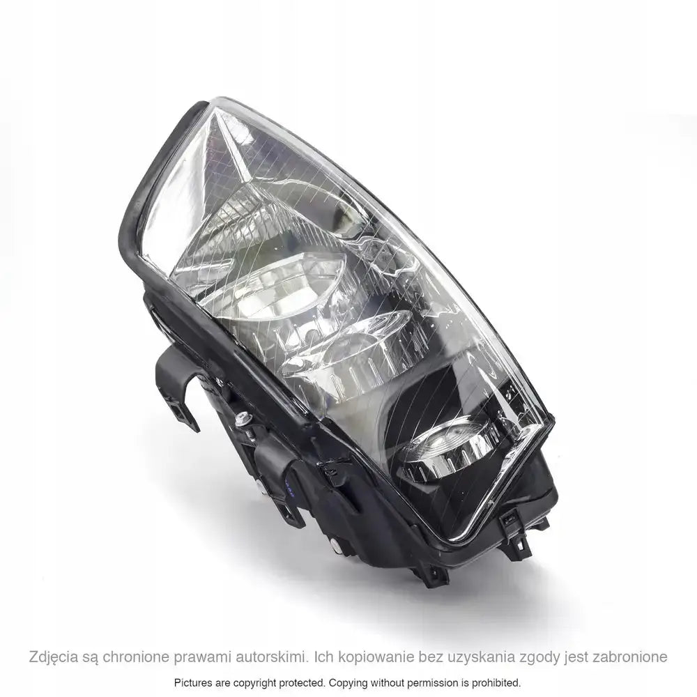 Hovedlykter Audi A4 B6 med klar plastlinse og svart hus sett i skrå vinkel ovenfra.