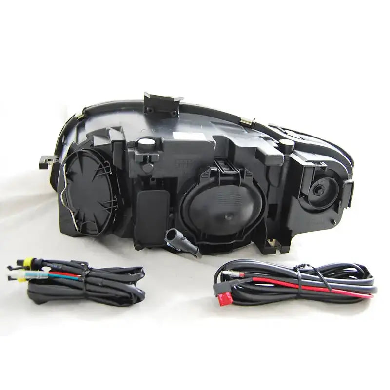 Hovedlykter Audi A4 B7 Black DRL sett bakfra med synlige deksler og ledningsnett på nøytral bakgrunn.