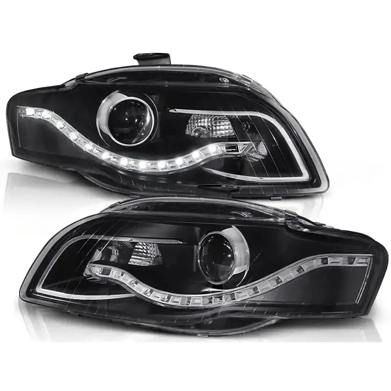 Hovedlykter Audi A4 B7 svarte med LED-lysstripe og reflektorer, vist fra skrå vinkel mot hvit bakgrunn.