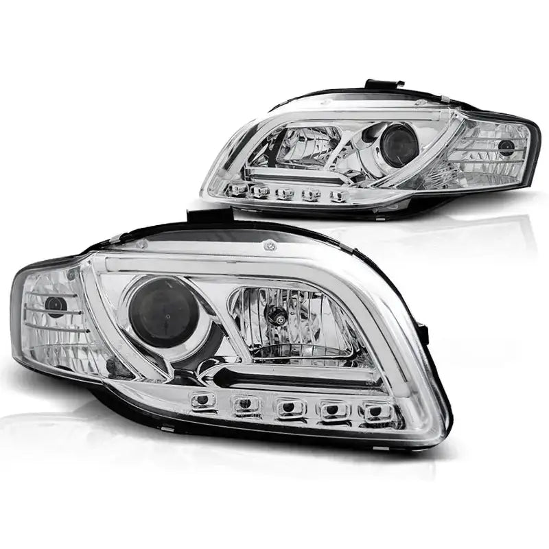 Frontlykter Audi A4 B7 Tube Lights Chrome med klar linse og innebygde LED-lys, sett fra skrå vinkel.