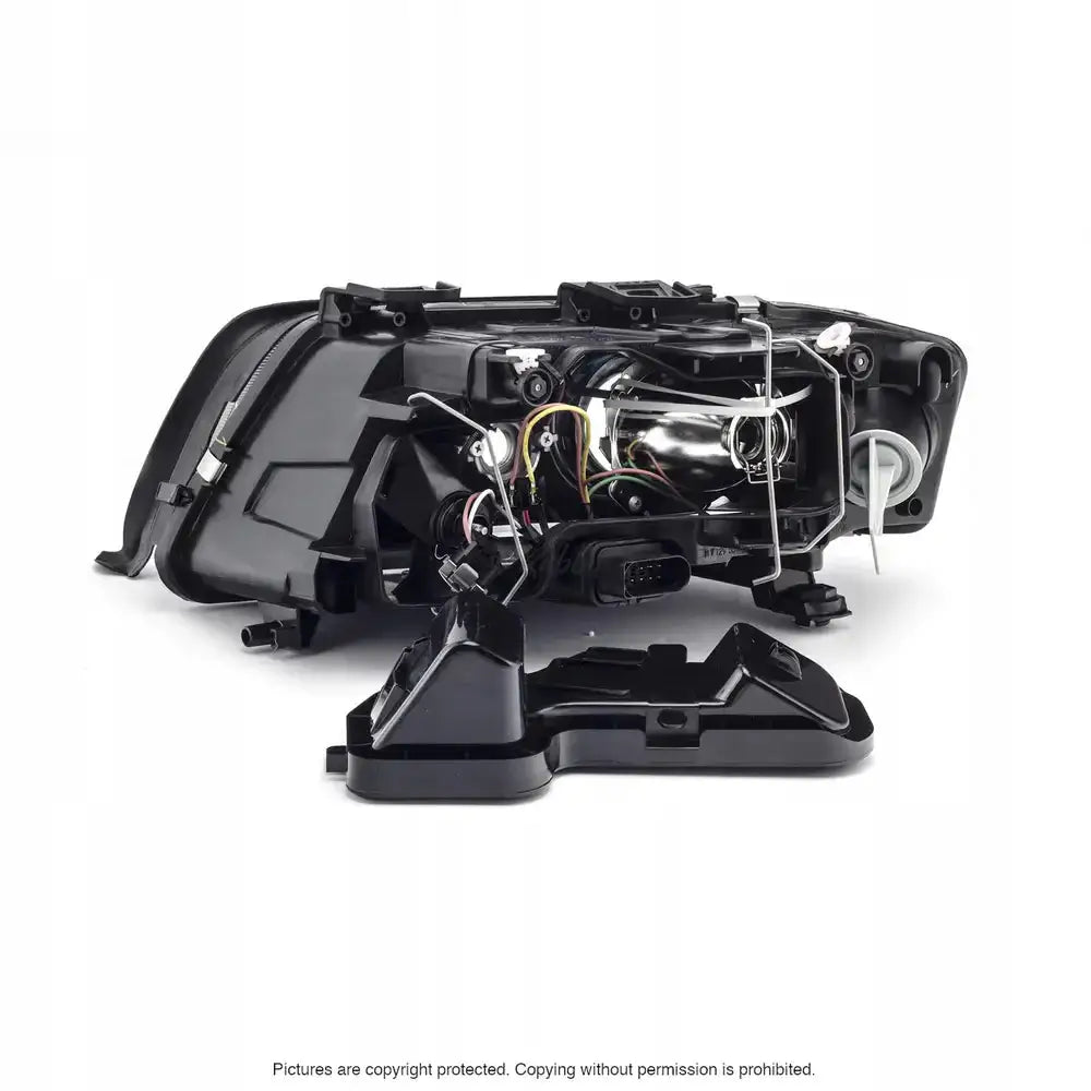 Frontlykter Audi A6 C5 sett bakfra med åpent deksel, synlige ledninger og elektroniske komponenter.