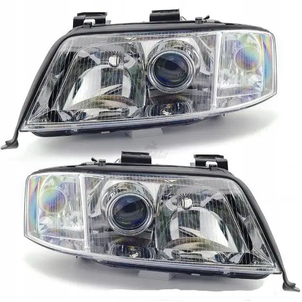Frontlykter Audi A6 C5 97-05 sett med klare linser og kromdetaljer, vist fra skrå forsidevinkel.