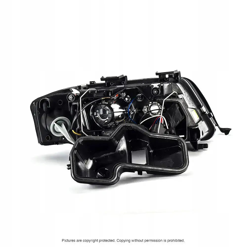 Headlamp Audi A6 C5 99-01 sett bakfra med synlige ledninger og komponenter mot hvit bakgrunn.