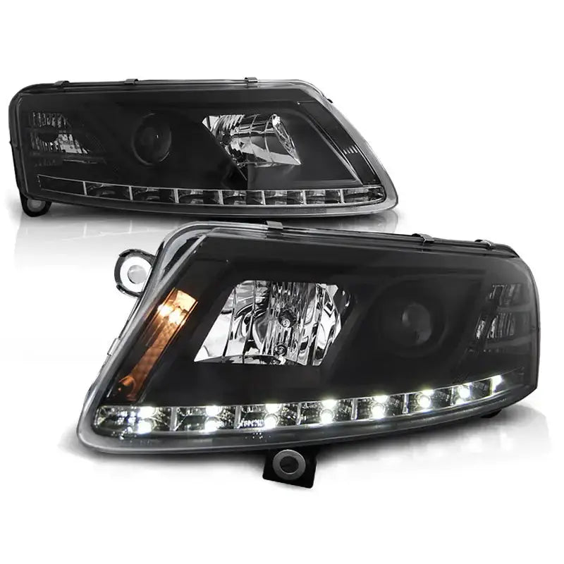 Frontlykter Audi A6 C6 Tru DRL Xenon D2S Black med LED-lys, sett fra skrå forside mot hvit bakgrunn.
