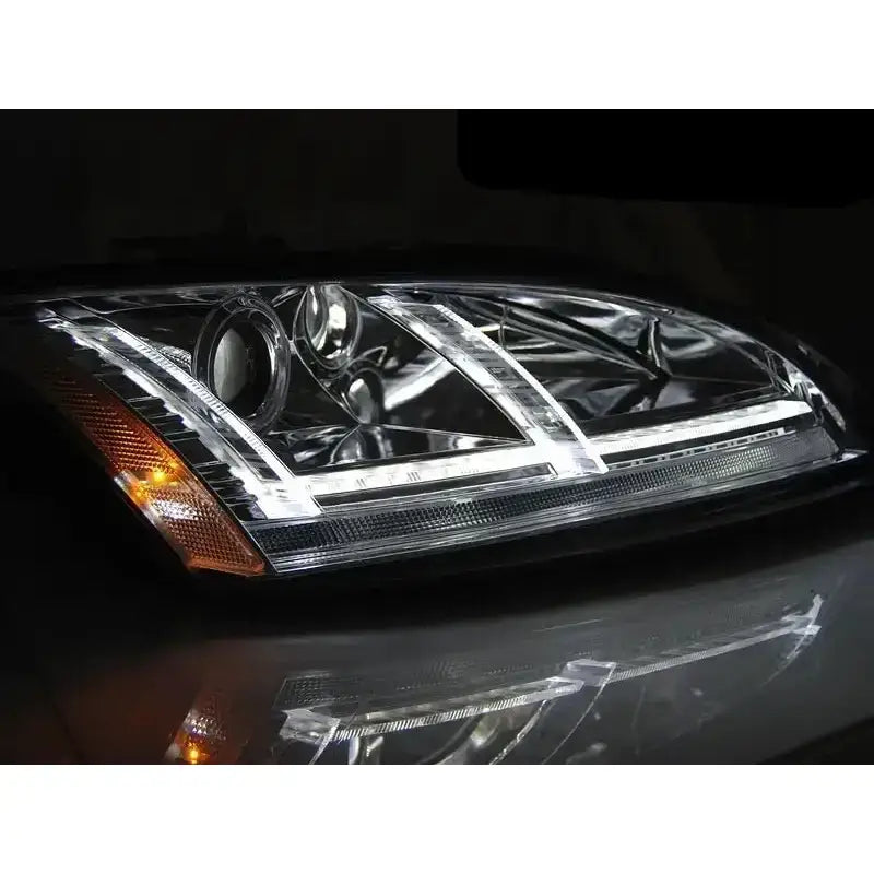 Frontlykter Audi TT 06-10 8J Chrome Led SEQ med klare LED-striper og kromdetaljer, tent mot mørk bakgrunn.