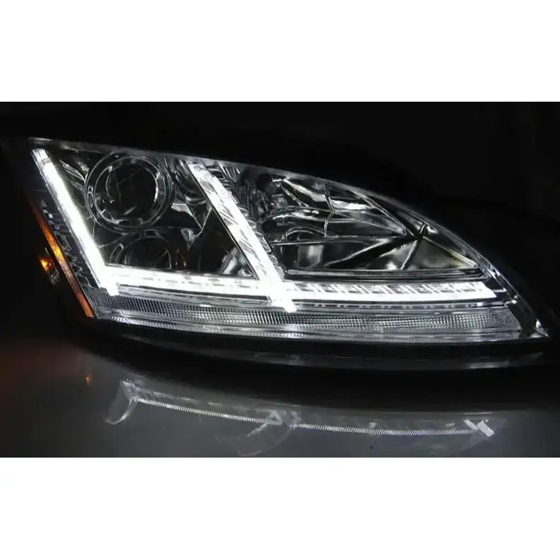 Headlights Audi TT 06-10 8J med kromdetaljer, LED-striper og klare linser sett fra skrå vinkel.